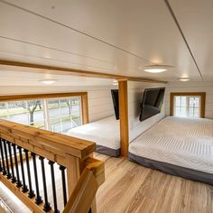 the inside of a tiny house with wood floors and white walls, an air mattress is on the bed