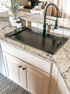 a kitchen counter top with a sink and faucet in the middle of it