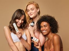 three beautiful women holding different types of skin care products