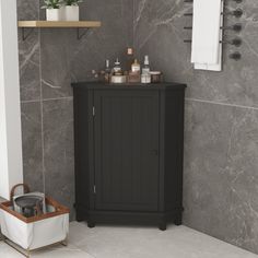 a bathroom with marble walls and flooring, including a black cabinet in the corner