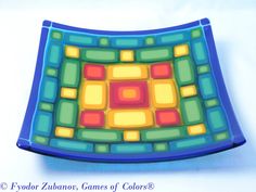 a colorful glass plate sitting on top of a white table