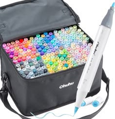 a bag filled with lots of different colored crayons next to a white pen