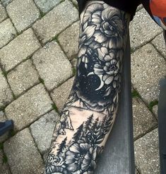 a person with a black and white tattoo on their arm is sitting on a bench