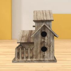 a wooden birdhouse with two holes in the roof