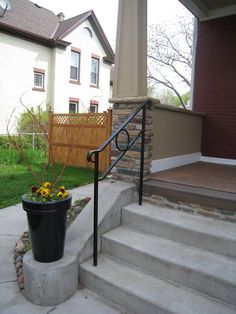 a potted plant sitting on the side of a set of steps next to a house