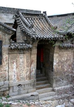 an old stone building with a red door