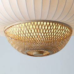 a close up of a light fixture on a white ceiling with wicker covering it