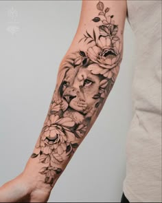 a woman's arm with a lion and flowers on it