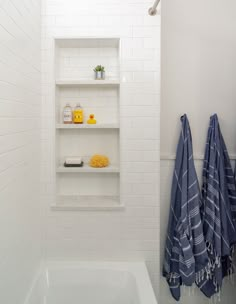 a bath room with a tub and a shelf filled with towels on top of it