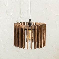 a wooden chandelier hanging from a ceiling with an electric light bulb in the center