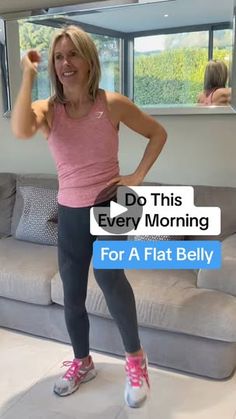 a woman standing in front of a couch with her arm up and the words do this every morning for a flat belly