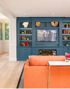 a living room filled with furniture and a flat screen tv mounted on a wall next to a fire place