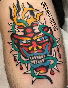 a man with a tattoo on his leg has a skull and flames in the background