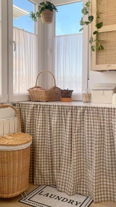 a kitchen with a table covered by a checkered tablecloth and two wicker baskets