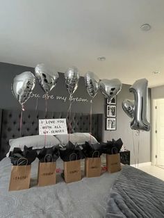 some balloons are hanging from the ceiling above a bed