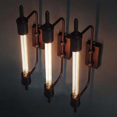 three lights are attached to the side of a wall mounted light fixture in an industrial style