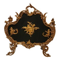 an ornately decorated black and gold plaque with cherubs on the front side