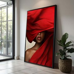 a framed photograph of a woman's head with red cloth draped over her face