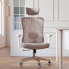 an office chair sitting on top of a hard wood floor next to a white table