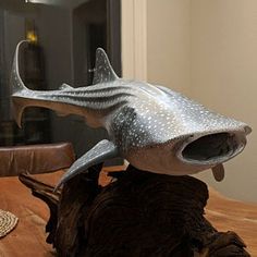 a statue of a shark on top of a wooden table