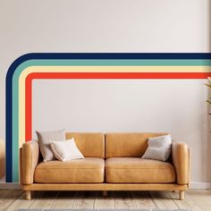 a living room with a couch and rainbow wall decal on the wall behind it