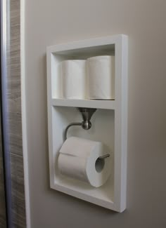 two rolls of toilet paper are hanging on the wall