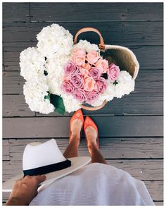 a woman's feet with her hat and flowers