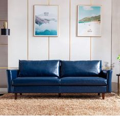 a blue leather couch sitting on top of a carpeted floor next to a wall