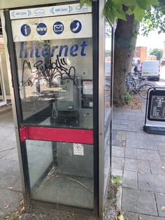 a public phone booth with graffiti on it