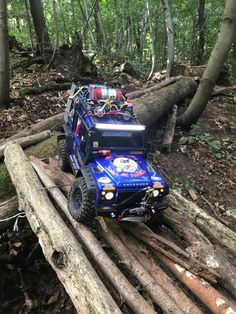 an off - road vehicle is on a log in the woods