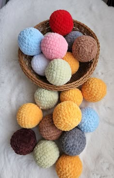 several crocheted balls in a basket on a white furnishing area with one red and one blue