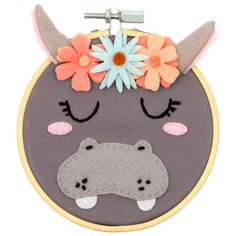 an embroidered animal with flowers on it's head is hanging from a hoop frame