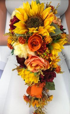 a bride holding a bouquet of sunflowers and roses