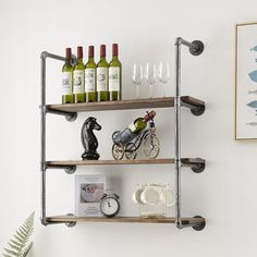 three shelves with wine glasses, figurines and other items on them against a white wall