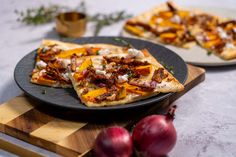 two slices of pizza sitting on top of a black plate