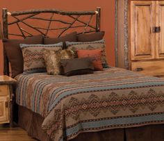 a bed with pillows and blankets on top of it next to a wooden dresser in a bedroom