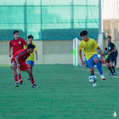 several young men playing soccer against each other