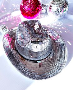 a shiny disco ball hat sitting on top of a white table next to another shiny object