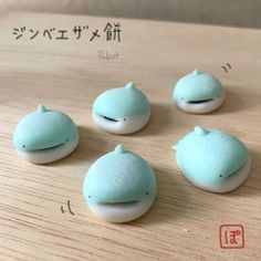 four small blue and white objects on a wooden surface with japanese characters in the background