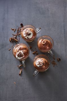 three cups filled with hot chocolate and whipped cream