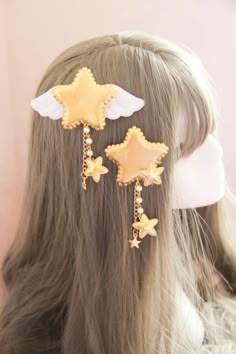 a close up of a person with long hair wearing ear clips and star shaped earrings