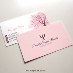 two pink business cards sitting on top of each other