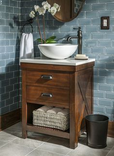 a bathroom vanity with a bowl sink and blue tiles on the wall in the background