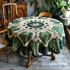 a table covered with a green and white crochet doily sitting on top of a wooden floor