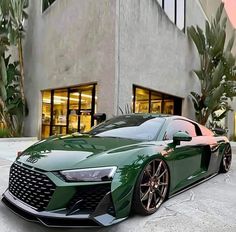 a green sports car parked in front of a building