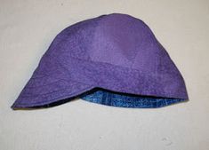 a purple hat sitting on top of a white wall