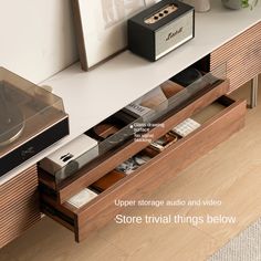 an entertainment center with drawers and electronic devices on the top shelf in front of it