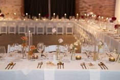 the tables are set with white linens and silverware for an elegant wedding reception