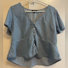 Like New Never Worn Light Blue Shirt With Buttons And Ruffle Short Sleeves. Casual Light Wash V-neck Top, Trendy Denim V-neck Top, Blue V-neck Denim Top For Summer, Trendy V-neck Denim Top For Summer, Trendy Light Blue V-neck Blouse, Medium Wash Denim V-neck Top, Light Blue V-neck Summer Shirt, Light Wash V-neck Top For Day Out, Casual Blue Short Sleeve V-neck Top