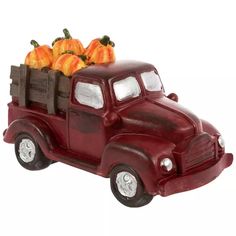 a red truck with pumpkins in the back